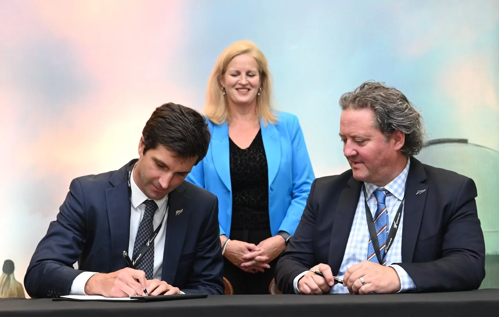 Sam Inglis (Left - Chief Operating Officer Ngāi Tahu Holdings) and Justin Watson (CEO Christchurch Airport) sign the partnership agreement in India with Tourism and Hospitality Minister Louise Upston in background.