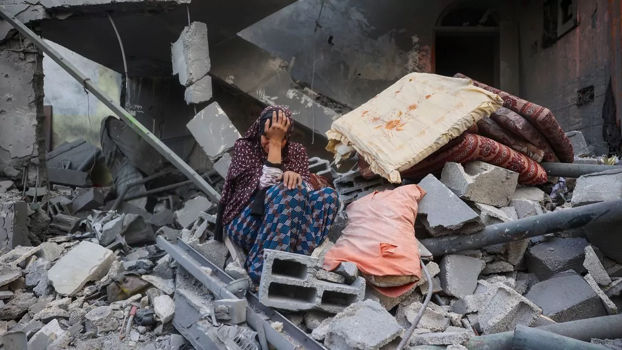 Eyad Baba/AFP/Getty Images A Palestinian woman sits on the rubble of her house, destroyed in an Israeli strike, in the Nuseirat refugee camp in central Gaza on Tuesday.